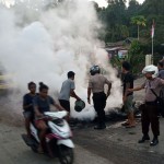 Petugas kepolisian bersama warga membersihkan ban yang dibakar seusai aksi di Jl.Essau Sesa Manokwari, Papua Barat. Foto: Media Indonesia/ANTARA/Toyiban