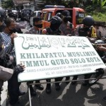 Polisi menurunkan papan bertuliskan Khilafatul Muslimin dari kantor cabang kelompok tersebut di Solo, Jawa Tengah, Kamis (9/6/2022). (CNN Indonesia/ANTARA FOTO/Maulana Surya)